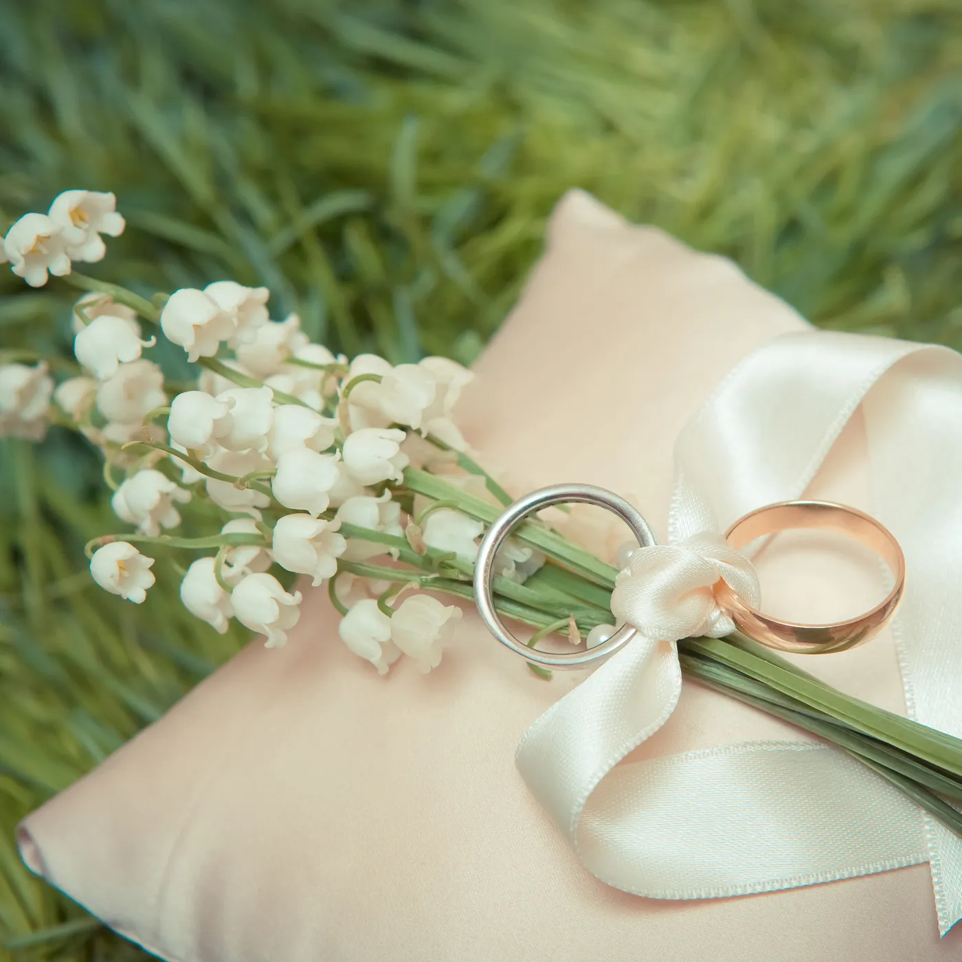 リングピローに置かれた結婚指輪とすずらん